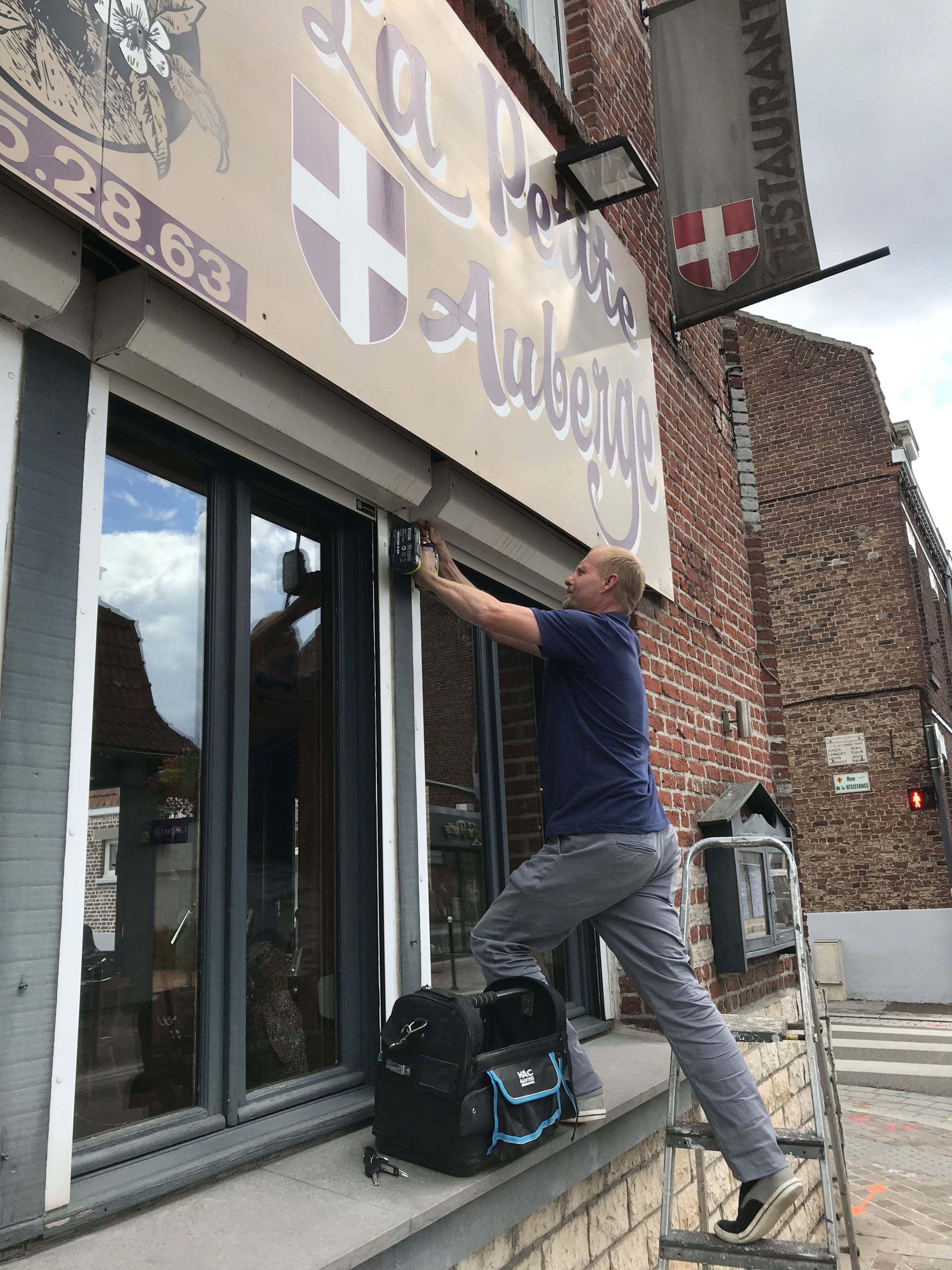 Technicien réparant la fermeture d’une vitrine de commerce