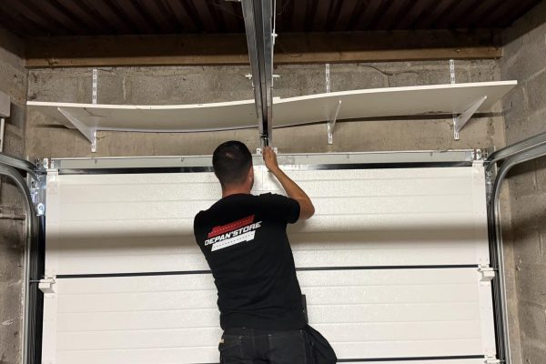 Technicien Depan’Store réglant une porte de garage sectionnelle