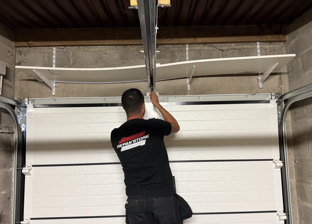Technicien Depan’Store réglant une porte de garage sectionnelle